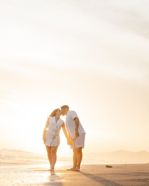 Pareja abrazada en la playa al atardecer